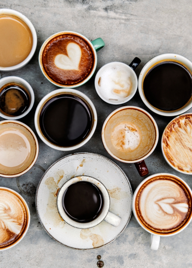 Verschiedene Kaffeespezialitäten auf einem Tisch von oben fotografiert