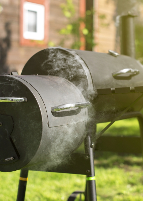 Ein qualmender Holzkohlegrill, in dem geräuchert wird