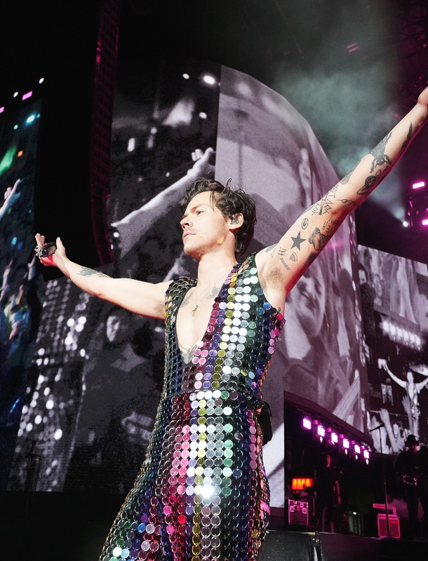 Sänger Harry Styles in einem glitzernden Paillettenanzug auf einer Bühne