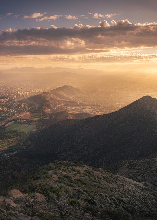 Luftbild von Santiago de Chile mit Sonne hinter Wolken