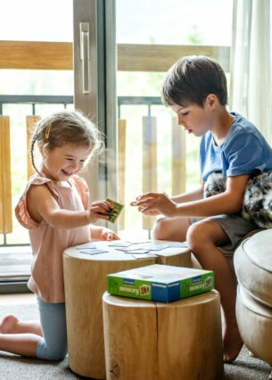 Zwei Kinder spielen in einem Hotelzimmer Memory