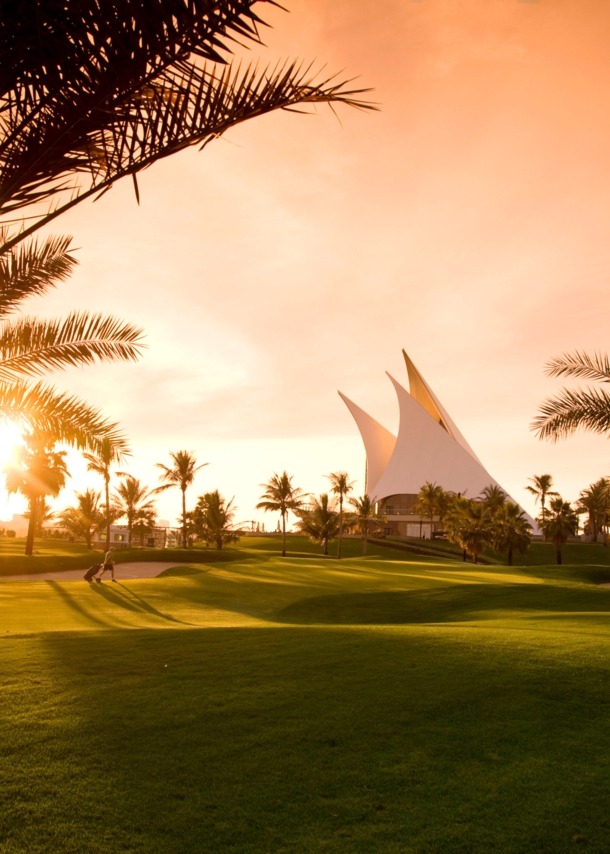 Ein gepflegter Golfplatz mit Palmen im Abendlicht