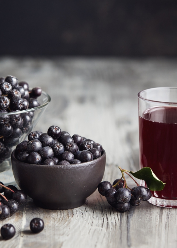 Saft aus Aroniabeeren und Aroniabeeren in Gläsern