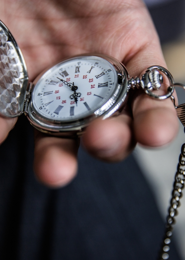 Eine Person hält eine aufgeklappte Taschenuhr in der Hand