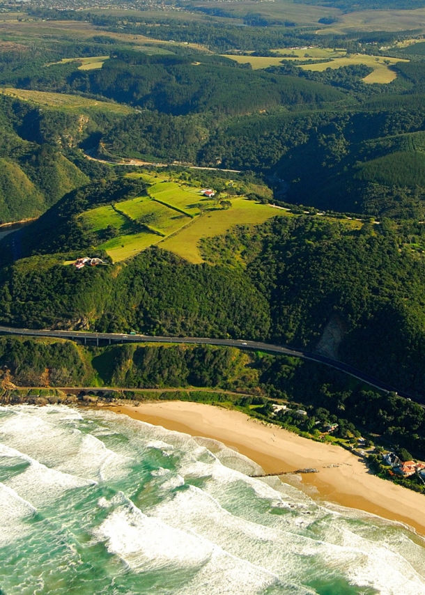 Luftaufnahme der Garden Route, die durch grüne Wälder entlang der Küste führt