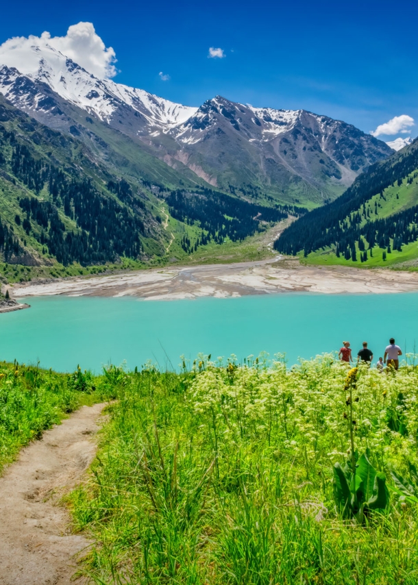 Blick auf den Almaty See in Kasachstan, der in ein Gebirge gebettet ist.