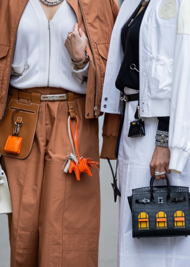 Bildausschnitt der Körpermitte von zwei Frauen, die Handtaschen tragen