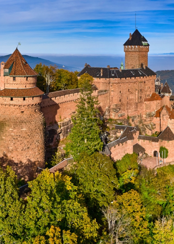 Panoramaaufnahme der mittelalterlichen Hohkönigsburg auf einem bewaldeten Hügel im Elsass