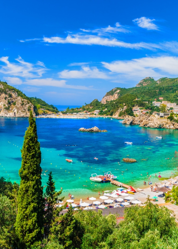 Blick über den Strand von Paleokastritsa mit türkisem Wasser und grüner Umgebung