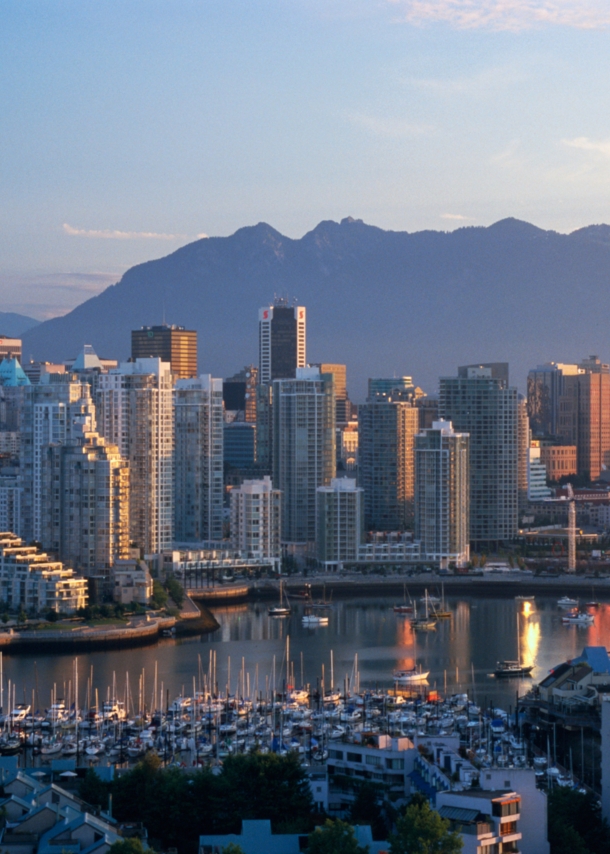 Skyline von Vancouver vor Bergpanorama in der Abenddämmerung.