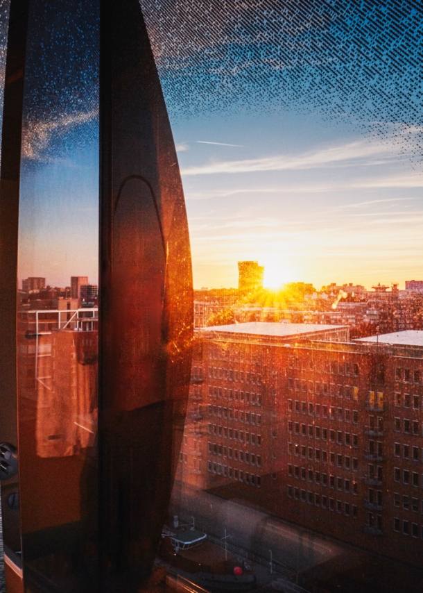 Stadtpanorama von Hamburg am Hafen aus einem geschwungenen Fenster bei Sonnenuntergang.