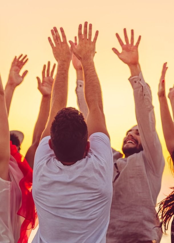 people dancing at the beach with hands up. concept about party, music and people