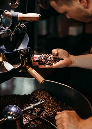 Ein Mann kontrolliert die Röstung von Kaffeebohnen