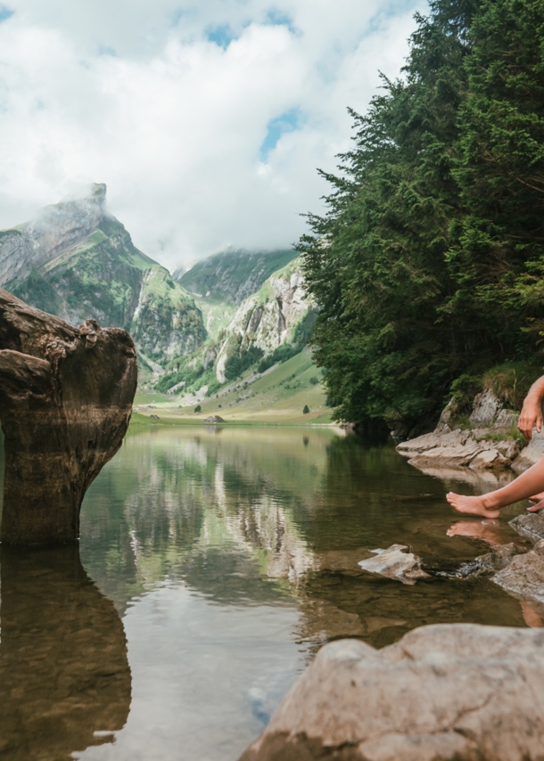 Ein Paar sitzt am Ufer eines idyllischen Bergsees im Sommer.