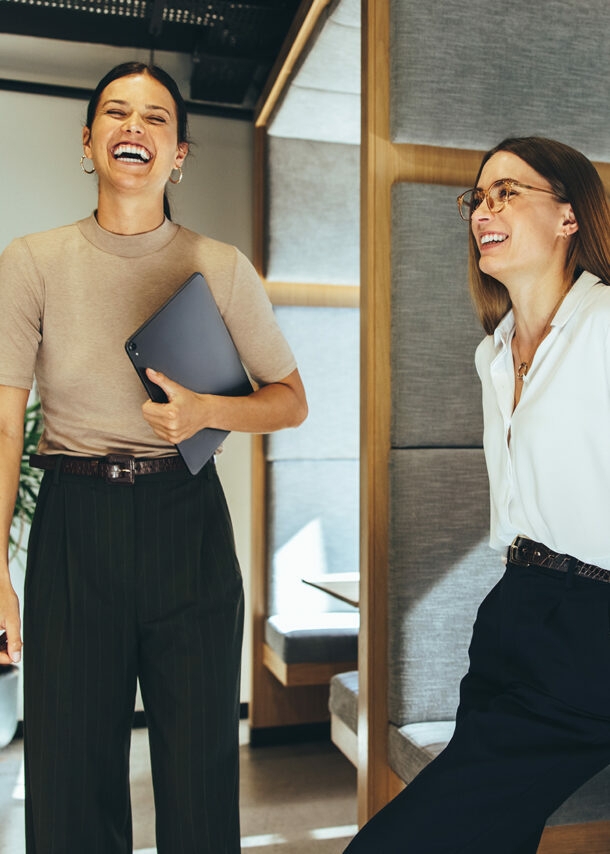 Zwei junge Geschäftsfrauen lachen im Büro