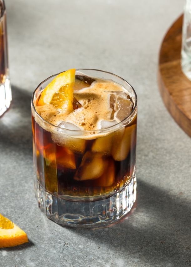 Zwei Gläser Espresso Tonic mit Eiswürfeln und Orangenscheiben.