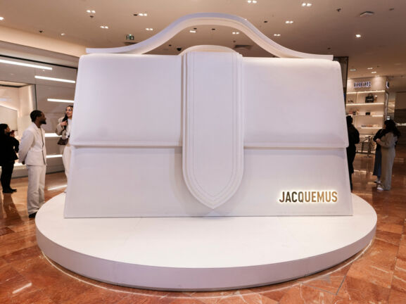 Alt-Text: Eine weiße, überdimensionale Le Bambino-Tasche des Designers Jacquemus in der Pariser Galeries Lafayette.