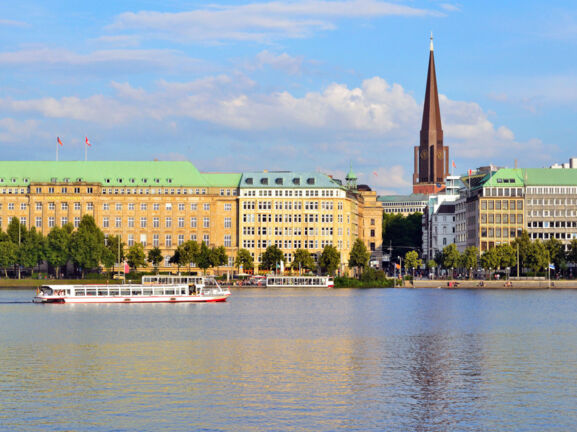 Häuserfront und Promenade am Wasser mit Booten in der Hamburger Altstadt.